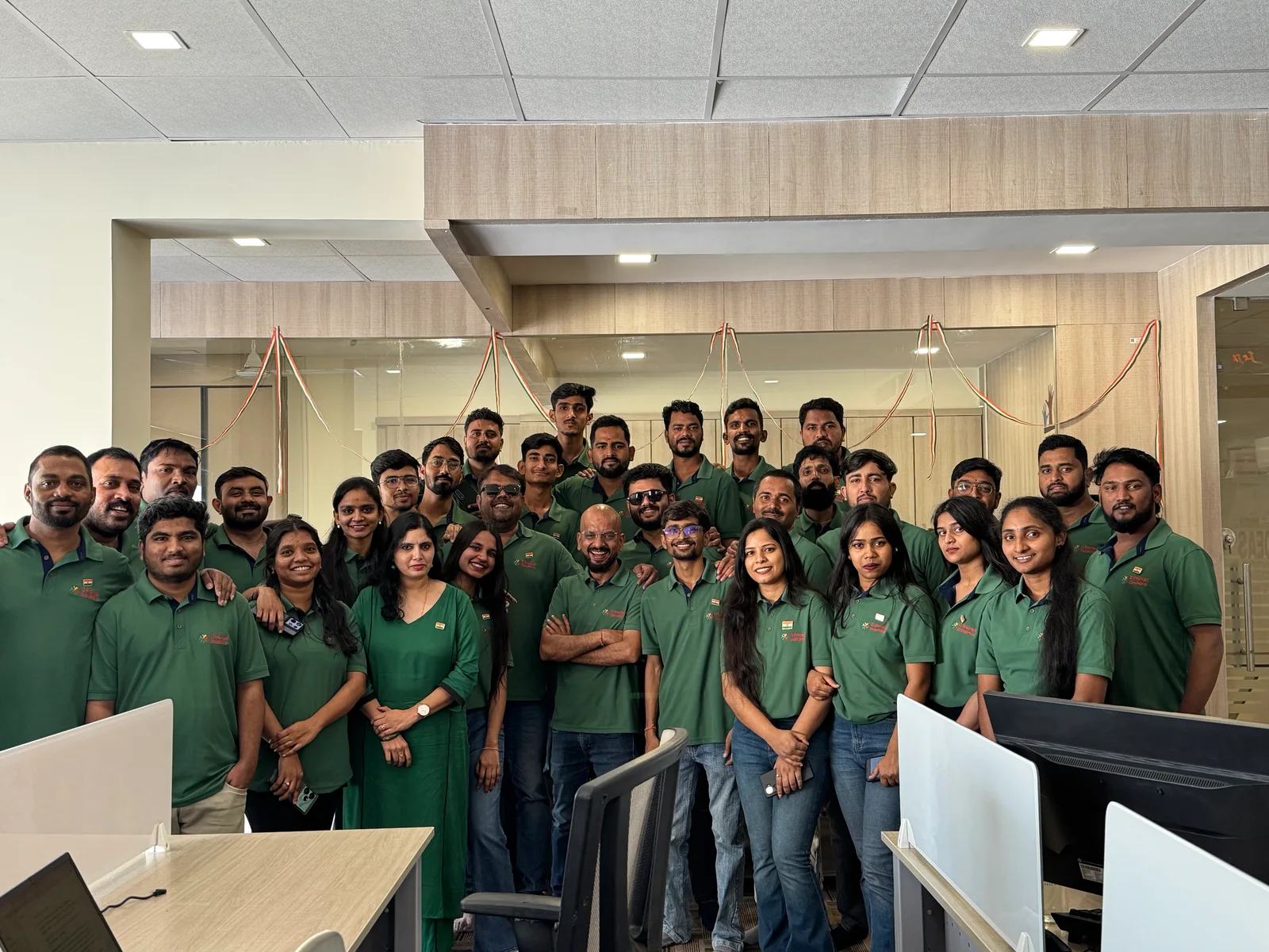 C Prompt team gathered among desks and monitors in the office.